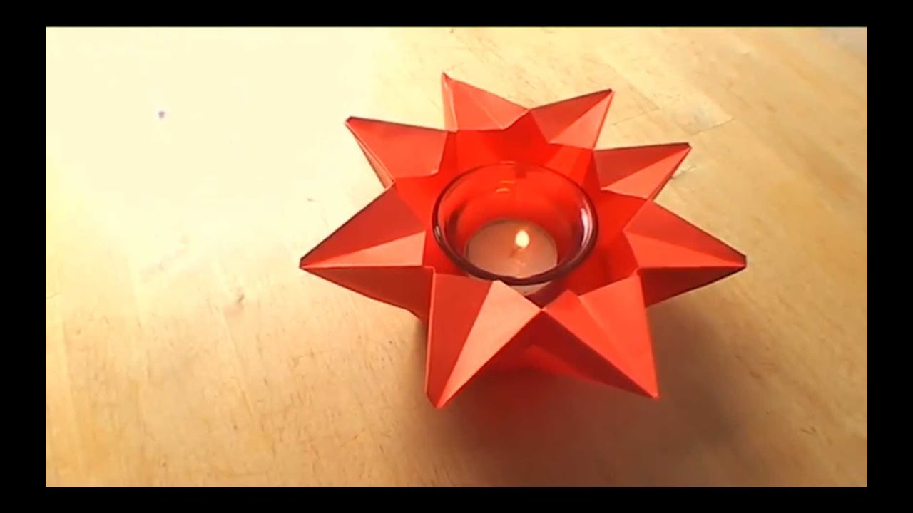 red origami star with candle in the center