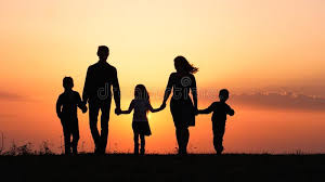 Silhouette of family holding hands against sunset