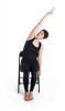 woman seated on chair and stretching