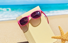 Book and sunglasses on beach